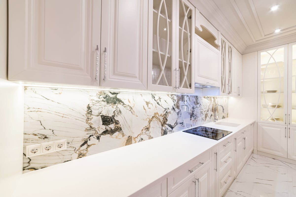 White kitchen in a new house with white countertop backlit appliances