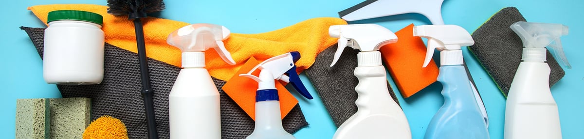 Cleaning products bottles rubber gloves and sponge