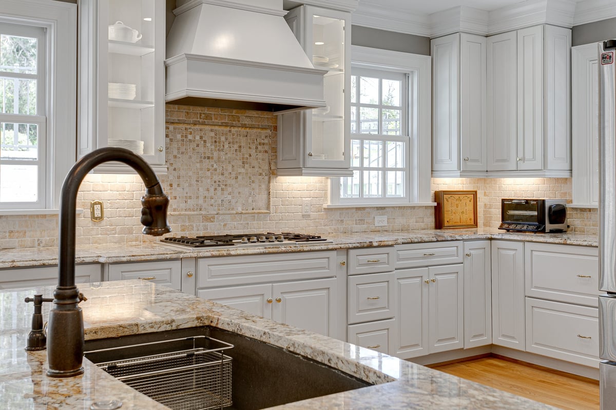 Clean modern kitchen with white cabinets and granite countertops