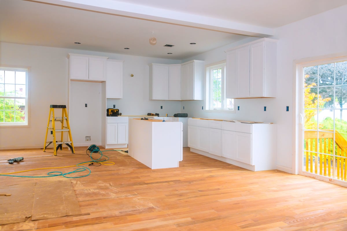 Bright, airy kitchen with new white cabinets and hardwood flooring