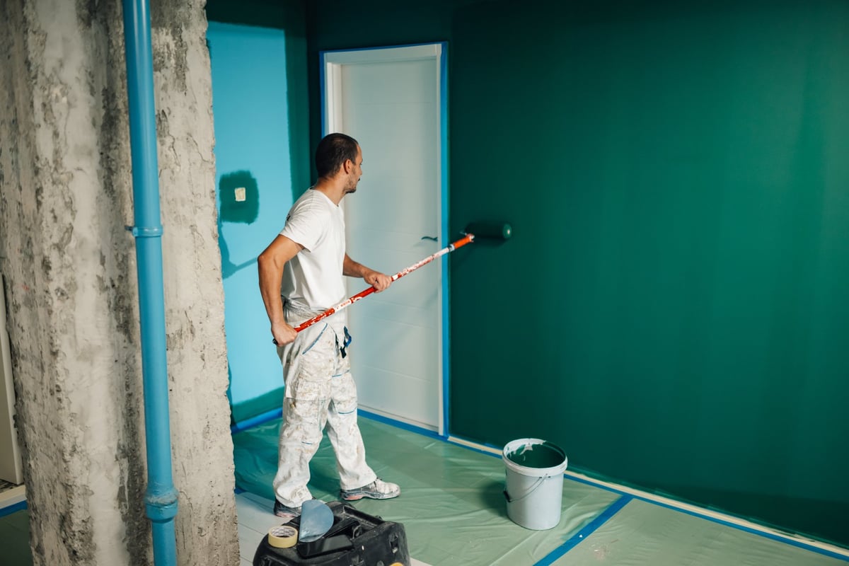 Professional painter applying paint to interior wall