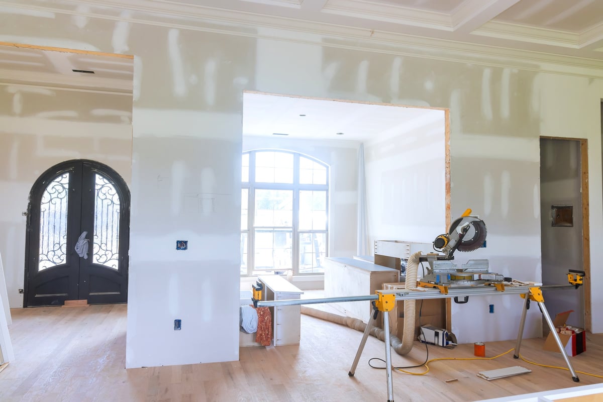Modern living space during home renovation featuring tools and unfinished walls